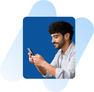 Ein Mann lächelt, während er auf sein Handy guckt.
